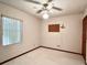 This bedroom features neutral walls and carpet, a ceiling fan, and a window with blinds at 407 Paradise Island Dr, Haines City, FL 33844