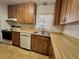 Kitchen featuring wood cabinetry, tile flooring, countertops and stainless steel double sink at 407 Paradise Island Dr, Haines City, FL 33844