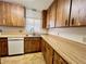 Kitchen featuring wood cabinetry, tile flooring, white dishwasher and countertops at 407 Paradise Island Dr, Haines City, FL 33844