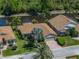 Charming single-story home with a brown roof, a brick driveway, mature landscaping, and waterfront views at 4168 Aberdeen Ln, Lake Wales, FL 33859