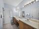 Bright bathroom features double sinks, a large mirror and wood-look tile floors at 4168 Aberdeen Ln, Lake Wales, FL 33859
