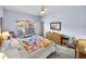 Bright bedroom with geometric quilt, window view, dresser, and ceiling fan at 4168 Aberdeen Ln, Lake Wales, FL 33859