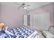 Bedroom featuring a comfortable bed with a purple quilt and a closet with double doors at 4168 Aberdeen Ln, Lake Wales, FL 33859