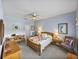Bright bedroom featuring a ceiling fan, wooden furniture, and a comfortable bed with a colorful quilt at 4168 Aberdeen Ln, Lake Wales, FL 33859