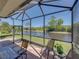 Screened-in lanai with outdoor seating provides stunning views of the water at 4168 Aberdeen Ln, Lake Wales, FL 33859