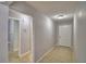 Hallway features tile floor, gray walls, and doors leading to the bathroom and entry to the house at 4174 Pirates Lndg, Winter Haven, FL 33884