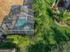 Aerial view of a screened-in pool and spa with lush greenery providing a private outdoor oasis at 4485 Turnberry Ln, Lake Wales, FL 33859