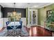 Formal dining area with zebra rug, modern chandelier, and decorative columns at 4485 Turnberry Ln, Lake Wales, FL 33859