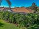 Home exterior featuring a screened-in pool area and tropical landscaping, providing a private backyard oasis at 4485 Turnberry Ln, Lake Wales, FL 33859