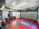 Organized garage with checkerboard flooring, featuring ample storage and space for multiple vehicles and equipment at 4485 Turnberry Ln, Lake Wales, FL 33859