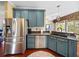 The kitchen features stainless steel appliances, blue cabinets, and a breakfast bar at 4485 Turnberry Ln, Lake Wales, FL 33859