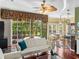 Bright living room with large windows, hardwood floors, ceiling fan, and access to outdoor pool at 4485 Turnberry Ln, Lake Wales, FL 33859