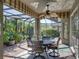 Outdoor dining on the covered patio with a view of the pool and lush landscaping at 4485 Turnberry Ln, Lake Wales, FL 33859