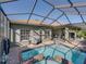 Enclosed pool area featuring a clear blue pool and hot tub, surrounded by a brick patio, offering an ideal outdoor space at 4485 Turnberry Ln, Lake Wales, FL 33859