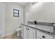 Modern bathroom with granite countertop, white cabinets, and dark fixtures at 4615 Reynosa Sw Dr, Winter Haven, FL 33880