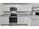 Updated kitchen with white cabinets, granite countertops, stainless steel appliances, and tile backsplash at 4615 Reynosa Sw Dr, Winter Haven, FL 33880