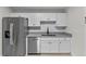 Updated kitchen featuring white cabinets, granite countertops, stainless steel appliances, and tile backsplash at 4615 Reynosa Sw Dr, Winter Haven, FL 33880