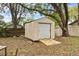 Exterior view of the storage shed featuring a metal door, wooden ramp, and backyard setting at 4615 Reynosa Sw Dr, Winter Haven, FL 33880