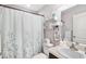 Well-lit bathroom with a vanity, toilet, decorative shelving, and a shower with curtain at 462 Lake View Way, Auburndale, FL 33823