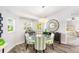 Bright dining room with glass table, striped chairs and decor at 462 Lake View Way, Auburndale, FL 33823