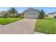 Paver driveway leading to a well-maintained home with lush landscaping at 462 Lake View Way, Auburndale, FL 33823