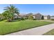 Beautiful single Gathering home with lush landscaping, mature palm trees, and a manicured lawn at 462 Lake View Way, Auburndale, FL 33823