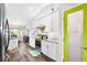 Bright kitchen featuring white cabinets, stainless steel appliances, a breakfast nook, and a green accent door at 462 Lake View Way, Auburndale, FL 33823