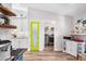 Stylish kitchen with a pop of color, featuring a bright green door and stainless steel appliances at 462 Lake View Way, Auburndale, FL 33823