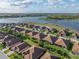 An aerial view of a beautiful home by the water, landscaped with palm trees and manicured lawns under a cloudy sky at 5556 Hogan Ln, Winter Haven, FL 33884