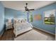 Light and airy bedroom with blue walls, a ceiling fan, and windows providing natural light at 5556 Hogan Ln, Winter Haven, FL 33884