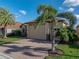 View of the home's exterior showcasing a large garage and lush landscaping with a beautiful brick driveway at 5556 Hogan Ln, Winter Haven, FL 33884