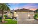 Charming single-story home featuring a large garage, lush landscaping, and a welcoming entrance with decorative stone accents at 5556 Hogan Ln, Winter Haven, FL 33884
