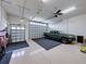 Spacious garage with epoxy flooring, a ceiling fan and two car garage doors at 5556 Hogan Ln, Winter Haven, FL 33884