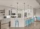 Bright, white kitchen featuring stainless steel appliances and modern blue bar stools at 5556 Hogan Ln, Winter Haven, FL 33884