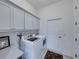 Bright laundry room featuring a new washer and dryer, and modern cabinetry at 5556 Hogan Ln, Winter Haven, FL 33884