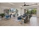 Bright living room features a ceiling fan, tile floors, coastal decor and sliding glass doors to the lanai at 5556 Hogan Ln, Winter Haven, FL 33884