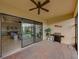 Covered patio with a brick floor, grill, and view of the living area through the sliding glass doors at 5556 Hogan Ln, Winter Haven, FL 33884