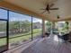 Inviting screened-in patio with ceiling fans and views of the manicured backyard and lush greenery at 5556 Hogan Ln, Winter Haven, FL 33884