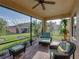 Screened-in patio featuring wicker furniture, brick flooring, ceiling fan, and serene backyard views at 5556 Hogan Ln, Winter Haven, FL 33884