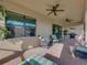 Covered patio with seating, an outdoor grill, and access to the interior through large sliding doors at 5556 Hogan Ln, Winter Haven, FL 33884