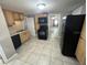 Well-lit kitchen boasts updated appliances, wood cabinets, and a seamless tile floor at 626 N Nashua Ave, Fort Meade, FL 33841