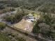 Aerial view of property featuring a home with a large yard, shed and carport at 6261 Red Grange Blvd, Indian Lake Estates, FL 33855
