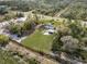 An aerial view showcases a home with a spacious, grassy yard, shed, and carport at 6261 Red Grange Blvd, Indian Lake Estates, FL 33855