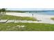 Easy beach access with concrete steps leading to a sandy beach and tranquil waters at 6261 Red Grange Blvd, Indian Lake Estates, FL 33855