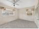 This bedroom features a ceiling fan, two windows, carpeted floors, and a closet at 6261 Red Grange Blvd, Indian Lake Estates, FL 33855