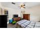 This bedroom features a ceiling fan, television, and carpeted floors at 6261 Red Grange Blvd, Indian Lake Estates, FL 33855