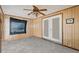 Wood paneled bedroom with a fan and carpeted flooring at 6261 Red Grange Blvd, Indian Lake Estates, FL 33855
