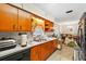 Eat-in kitchen features wood cabinets and a stainless steel double sink with backyard view at 6261 Red Grange Blvd, Indian Lake Estates, FL 33855