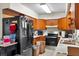 Kitchen view with black refrigerator, wood cabinets, stainless steel oven and sink at 6261 Red Grange Blvd, Indian Lake Estates, FL 33855
