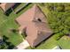 Aerial view of a home featuring a brown roof, mature trees and green grass at 633 Hart Lake Dr, Winter Haven, FL 33884